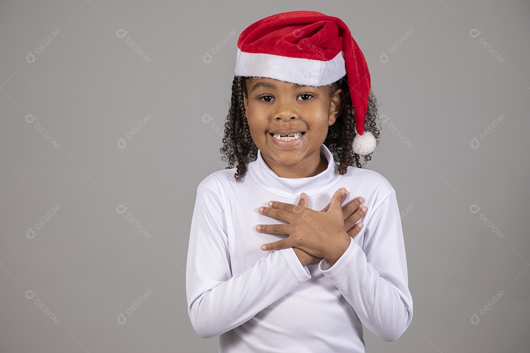 Linda garotinha sorridente usando roupa do papai Noel celebrando natal