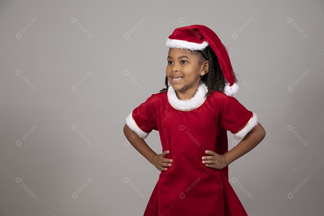 Linda garotinha sorridente usando roupa do papai Noel celebrando natal