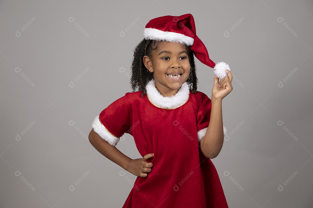 Linda garotinha sorridente usando roupa do papai Noel celebrando natal