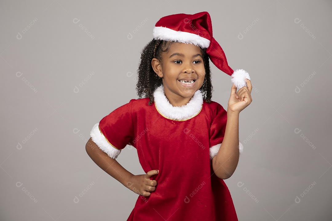 Linda garotinha sorridente usando roupa do papai Noel celebrando natal
