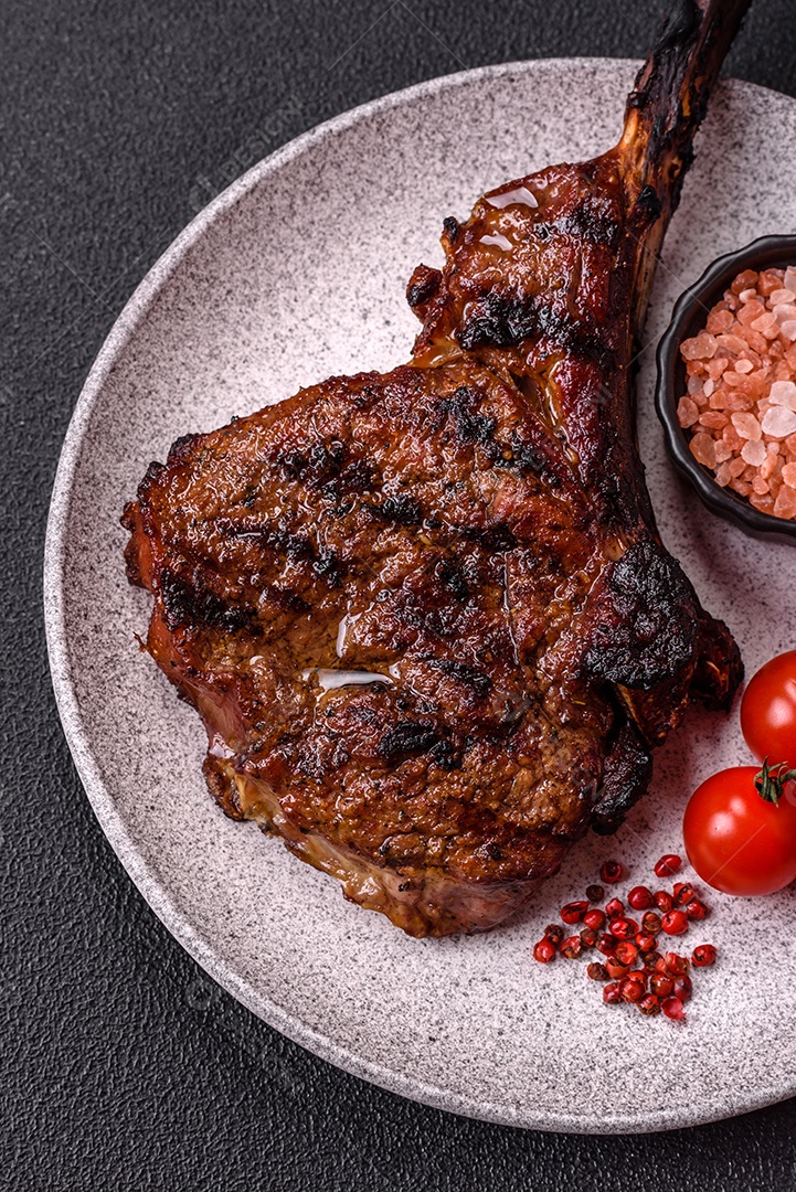 A imagem mostra um Tomahawk Steak, um corte de carne bovina reconhecível pelo seu longo osso da costela