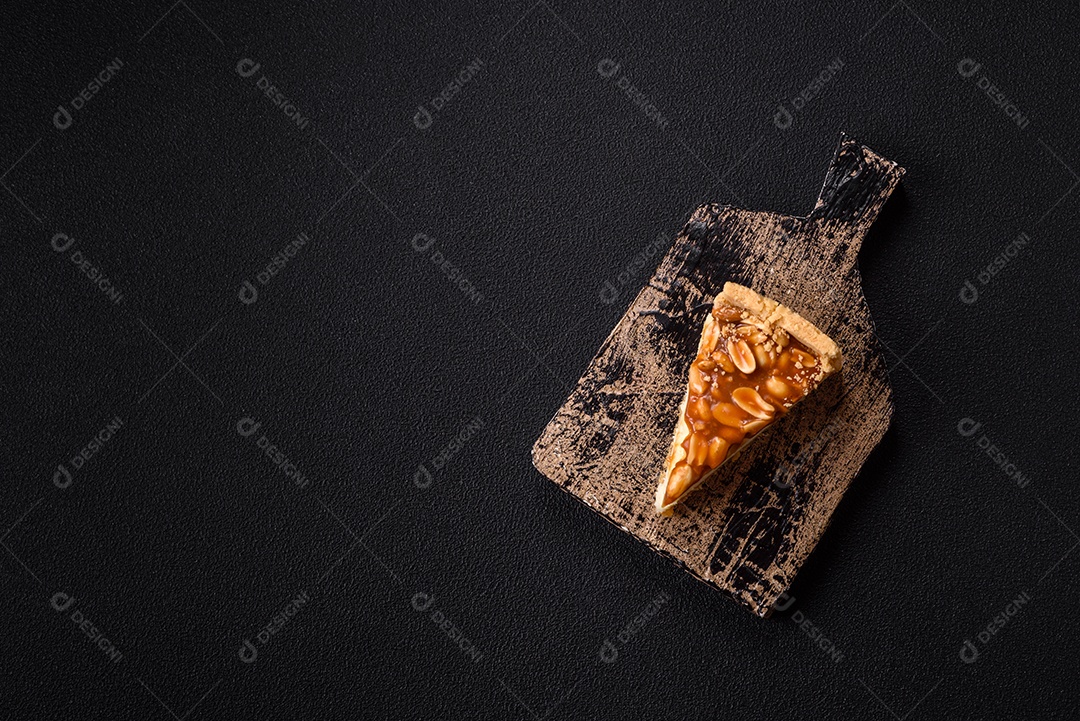 A imagem mostra uma fatia de cheesecake, possivelmente com uma cobertura de caramelo e nozes.