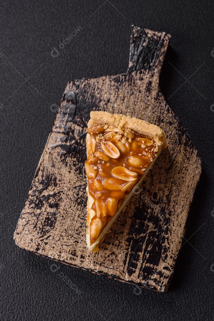 A imagem mostra uma fatia de cheesecake, possivelmente com uma cobertura de caramelo e nozes.