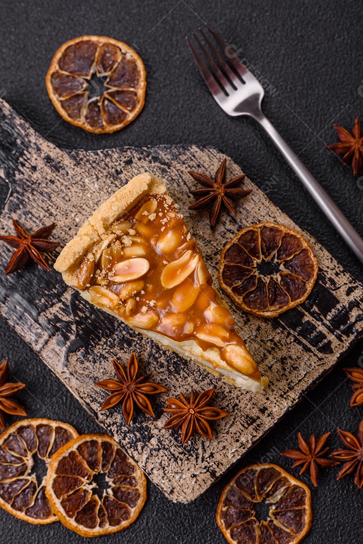 A imagem mostra uma fatia de cheesecake, possivelmente com uma cobertura de caramelo e nozes.