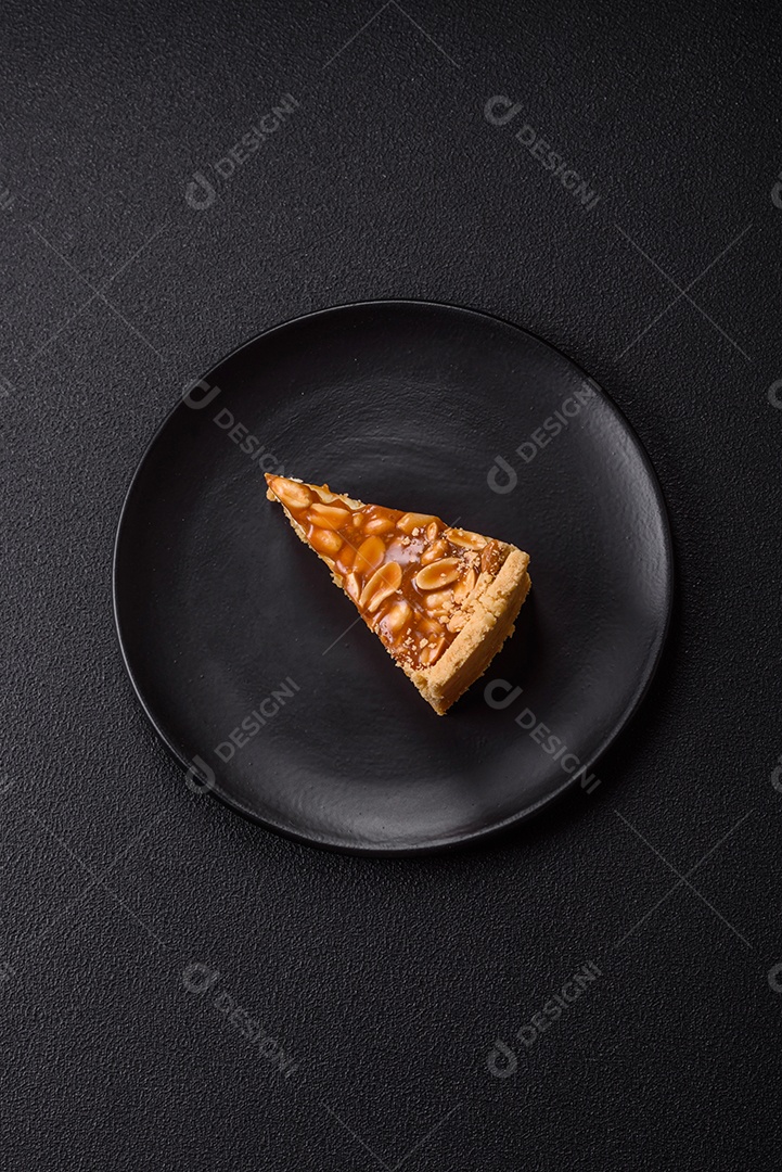 A imagem mostra uma fatia de cheesecake, possivelmente com uma cobertura de caramelo e nozes.