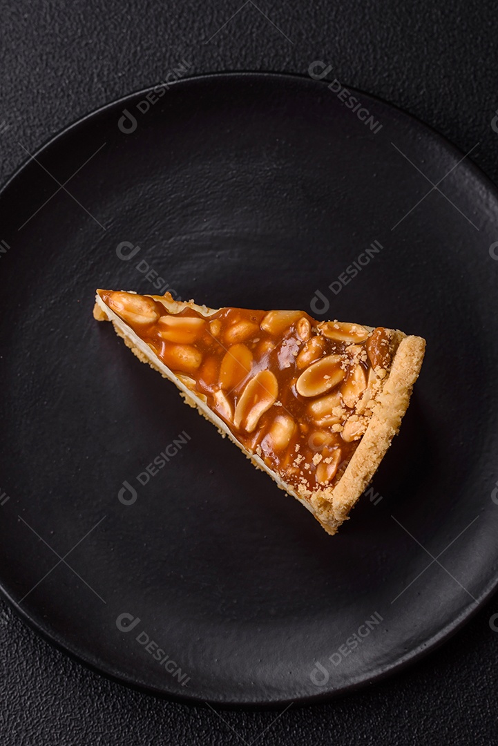 A imagem mostra uma fatia de cheesecake, possivelmente com uma cobertura de caramelo e nozes.