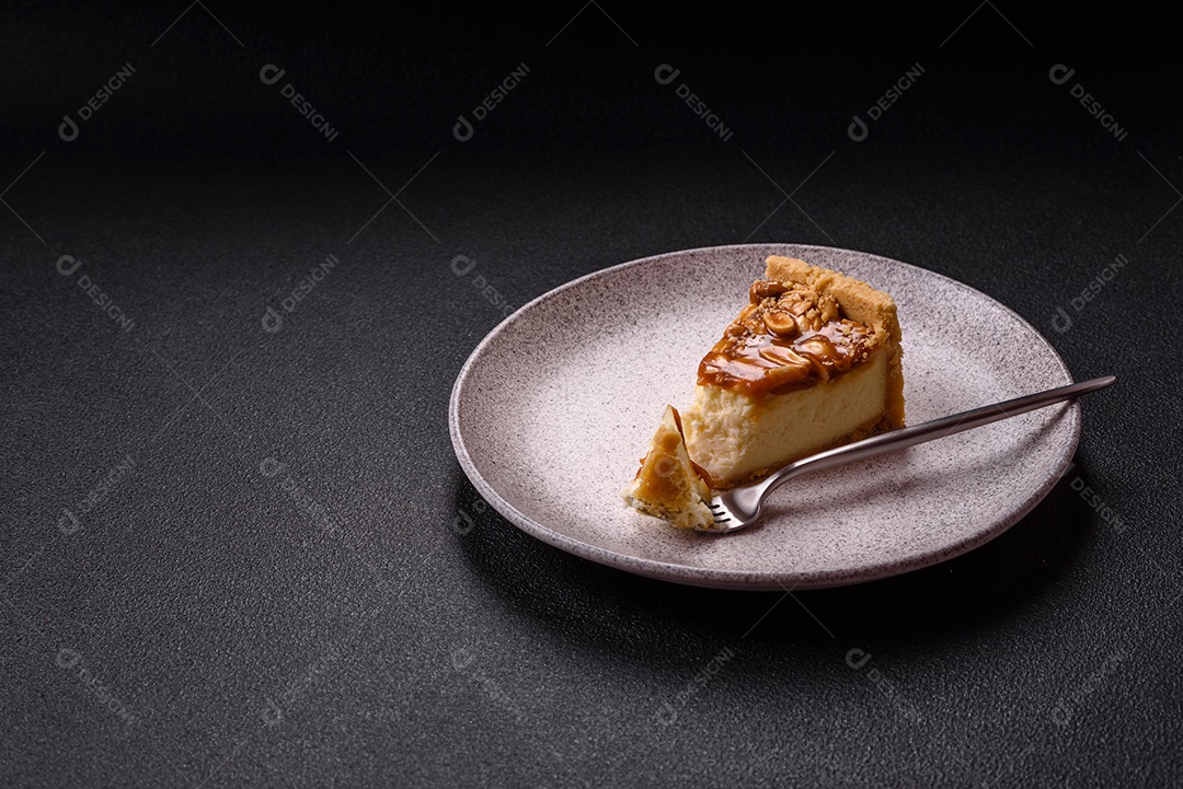 A imagem mostra uma fatia de cheesecake, possivelmente com uma cobertura de caramelo e nozes.