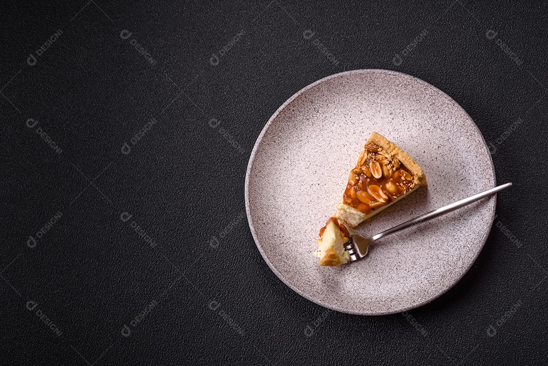 A imagem mostra uma fatia de cheesecake, possivelmente com uma cobertura de caramelo e nozes.