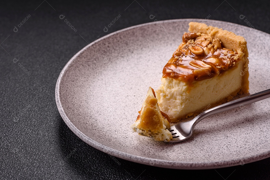 A imagem mostra uma fatia de cheesecake, possivelmente com uma cobertura de caramelo e nozes.