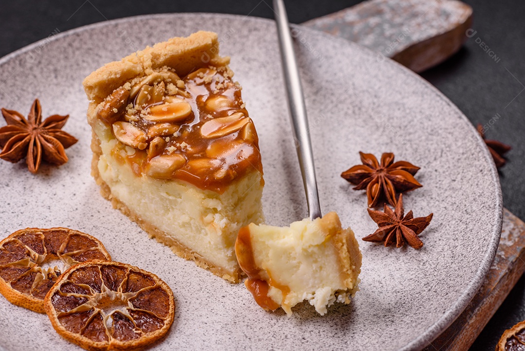 A imagem mostra uma fatia de cheesecake, possivelmente com uma cobertura de caramelo e nozes.