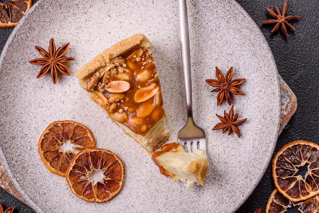 A imagem mostra uma fatia de cheesecake, possivelmente com uma cobertura de caramelo e nozes.