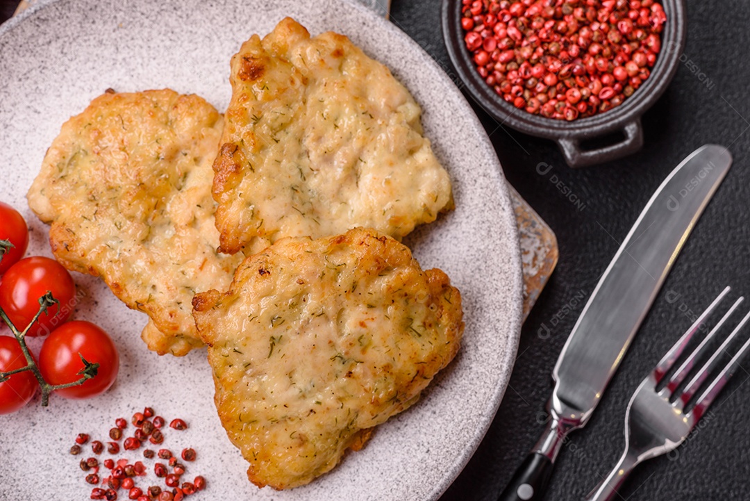 A imagem mostra dois bolinhos de carne fritos, acompanhados de um molho vermelho