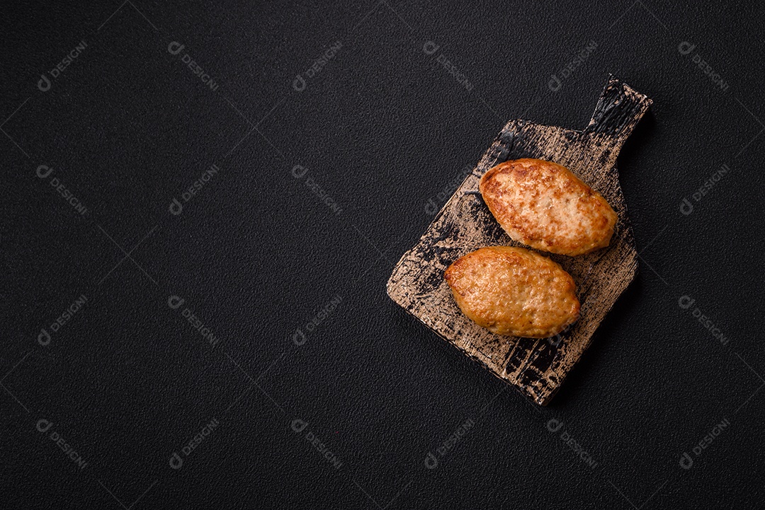 A imagem mostra dois bolinhos de carne fritos, acompanhados de um molho vermelho