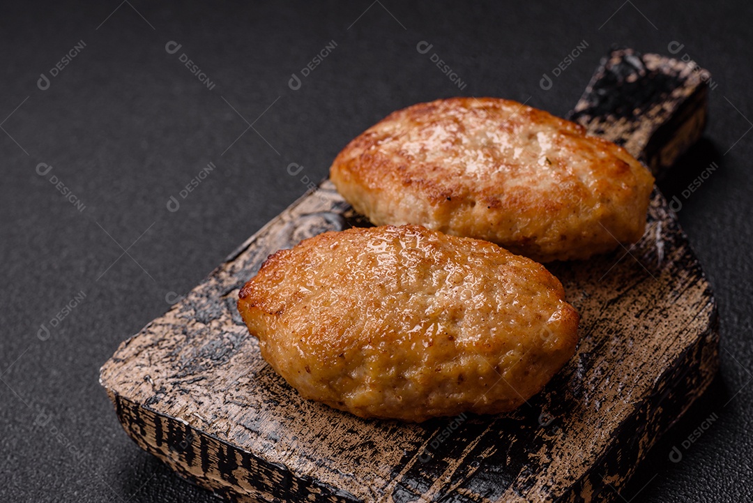 A imagem mostra dois bolinhos de carne fritos, acompanhados de um molho vermelho