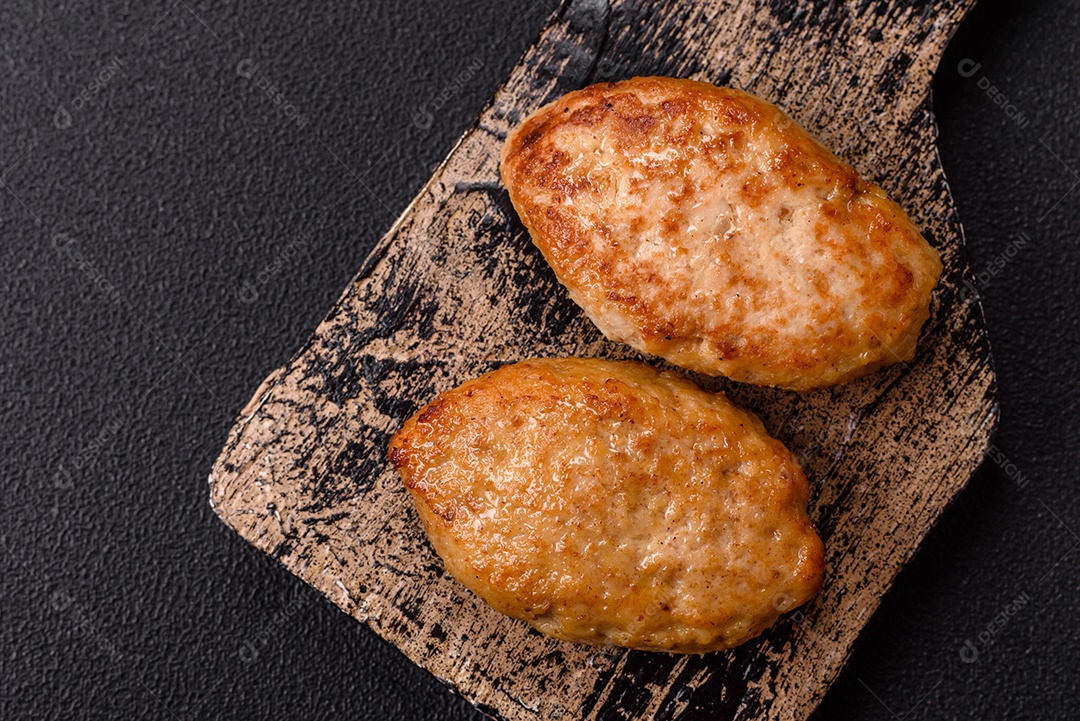 A imagem mostra dois bolinhos de carne fritos, acompanhados de um molho vermelho