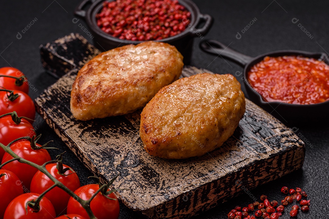 A imagem mostra dois bolinhos de carne fritos, acompanhados de um molho vermelho