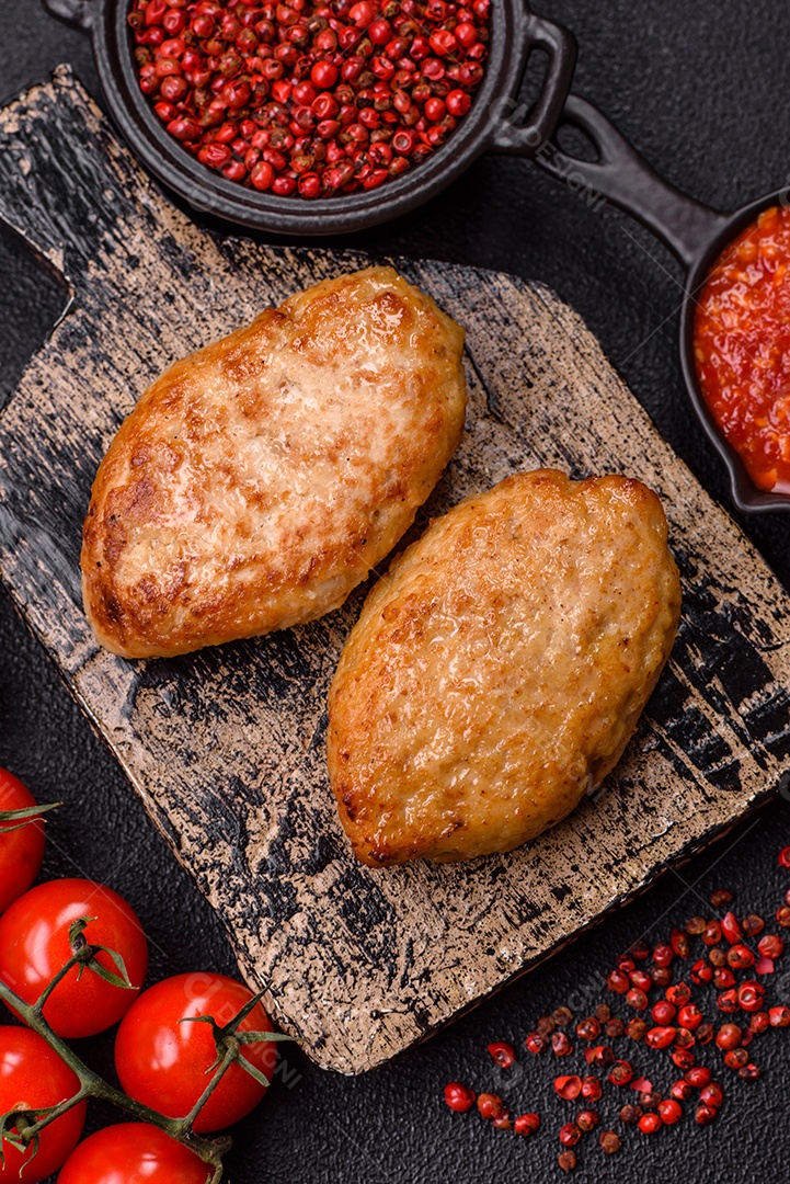 A imagem mostra dois bolinhos de carne fritos, acompanhados de um molho vermelho