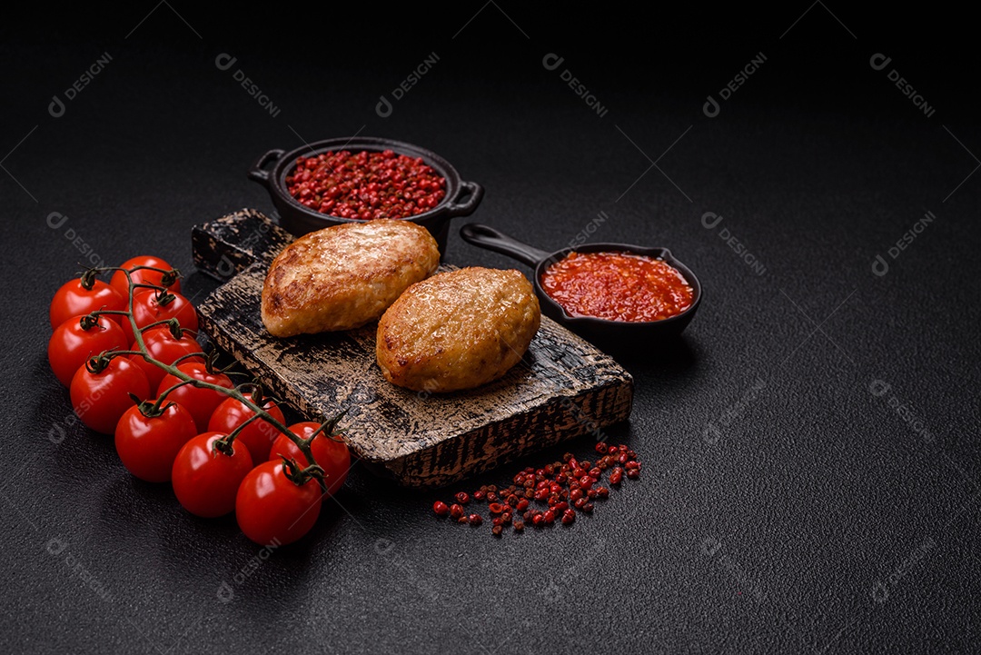A imagem mostra dois bolinhos de carne fritos, acompanhados de um molho vermelho