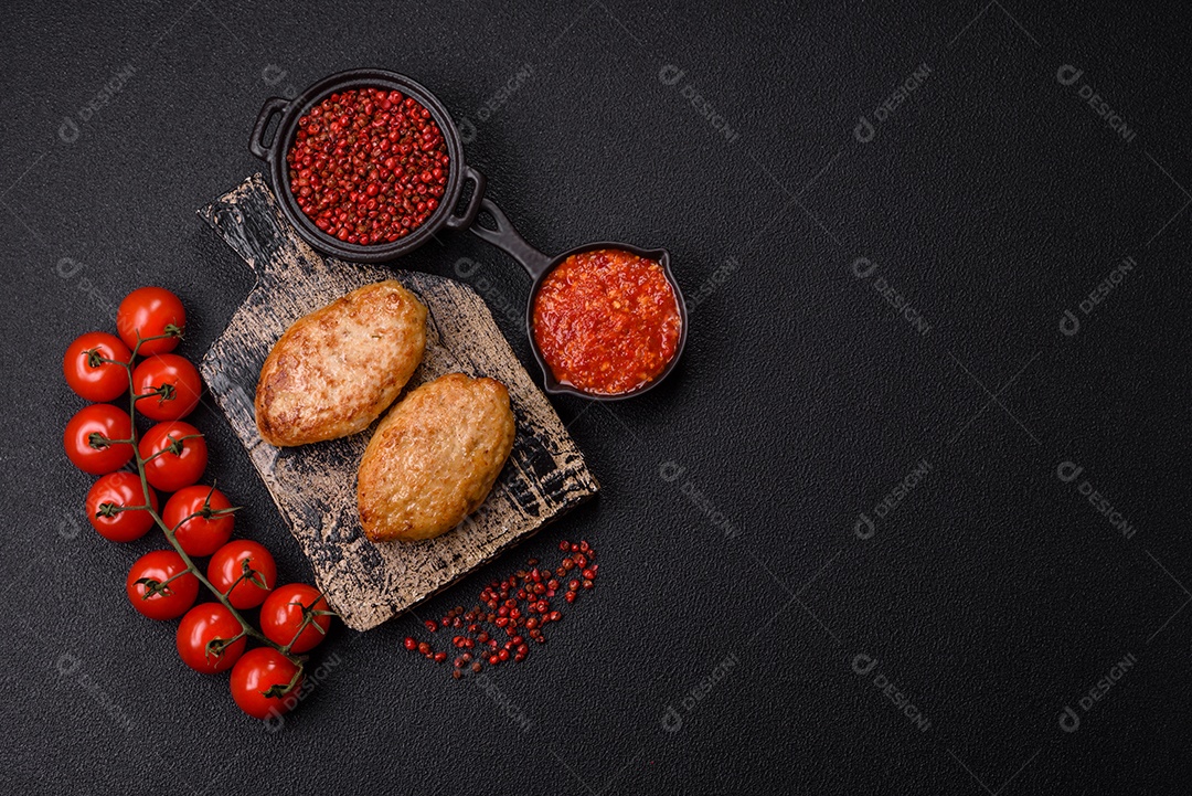 A imagem mostra dois bolinhos de carne fritos, acompanhados de um molho vermelho