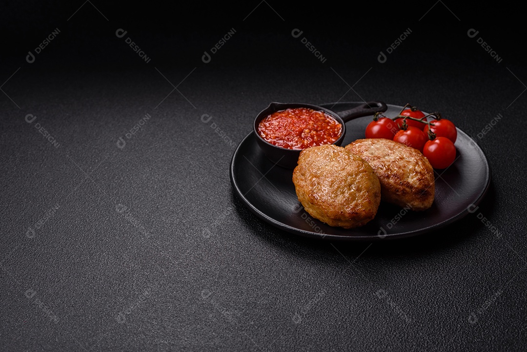 A imagem mostra dois bolinhos de carne fritos, acompanhados de um molho vermelho