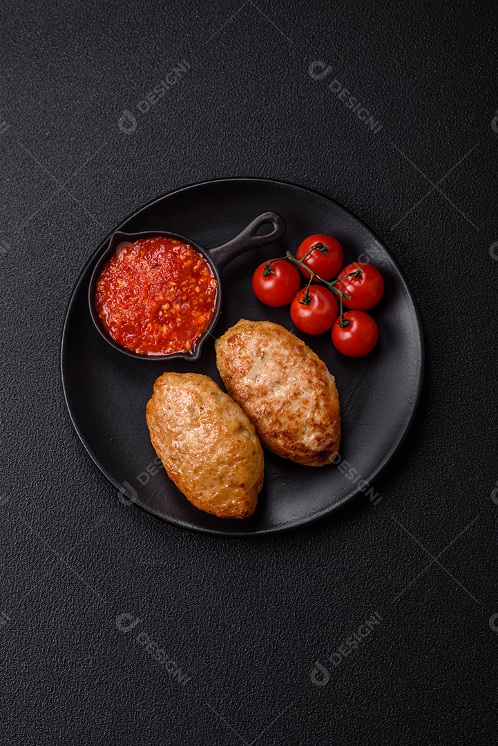 A imagem mostra dois bolinhos de carne fritos, acompanhados de um molho vermelho