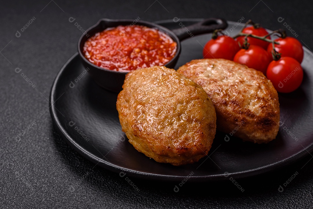 A imagem mostra dois bolinhos de carne fritos, acompanhados de um molho vermelho