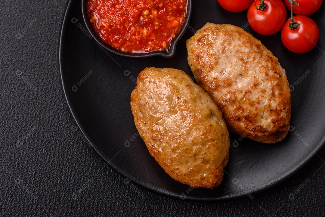 A imagem mostra dois bolinhos de carne fritos, acompanhados de um molho vermelho