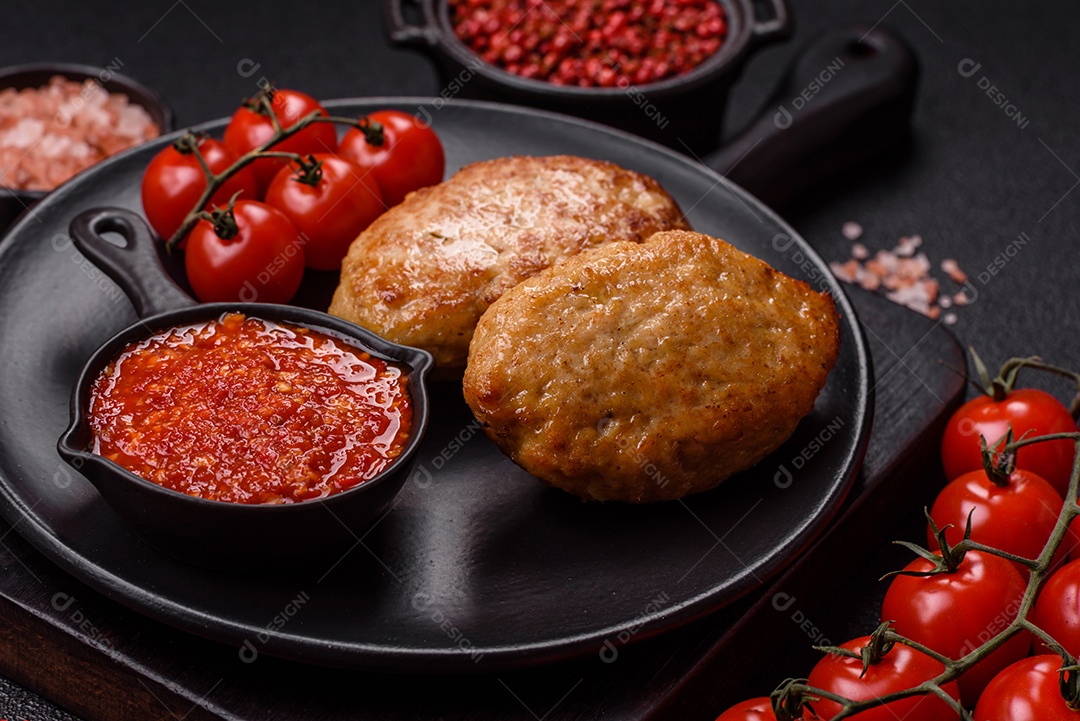A imagem mostra dois bolinhos de carne fritos, acompanhados de um molho vermelho