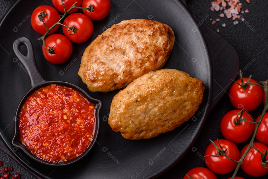 A imagem mostra dois bolinhos de carne fritos, acompanhados de um molho vermelho