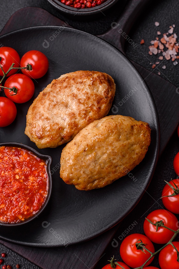 A imagem mostra dois bolinhos de carne fritos, acompanhados de um molho vermelho