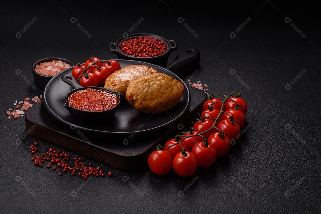 A imagem mostra dois bolinhos de carne fritos, acompanhados de um molho vermelho