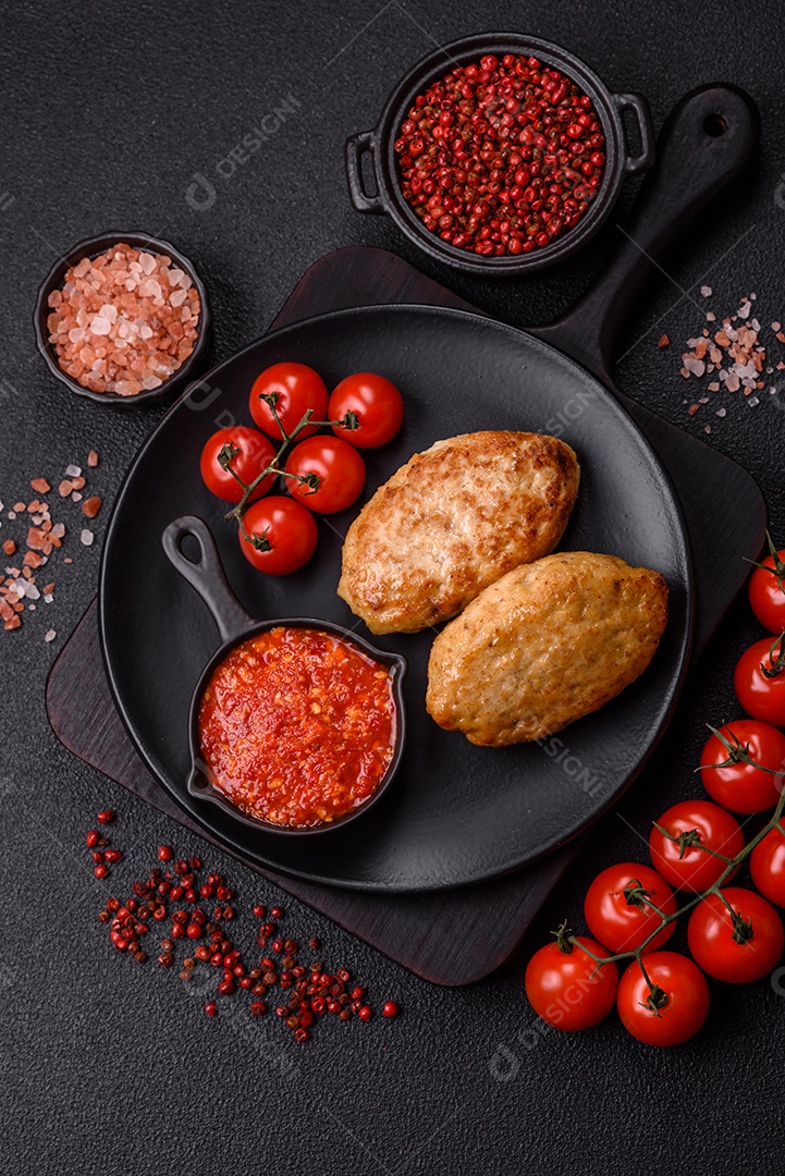 A imagem mostra dois bolinhos de carne fritos, acompanhados de um molho vermelho