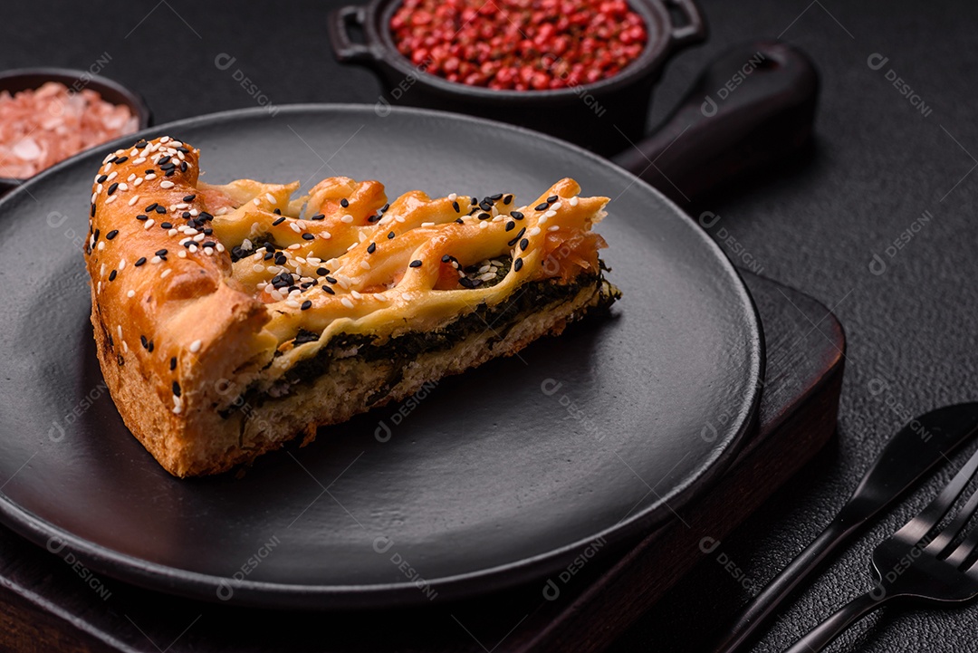 Imagem mostra uma fatia de torta salgada, possivelmente uma torta de espinafre com queijo