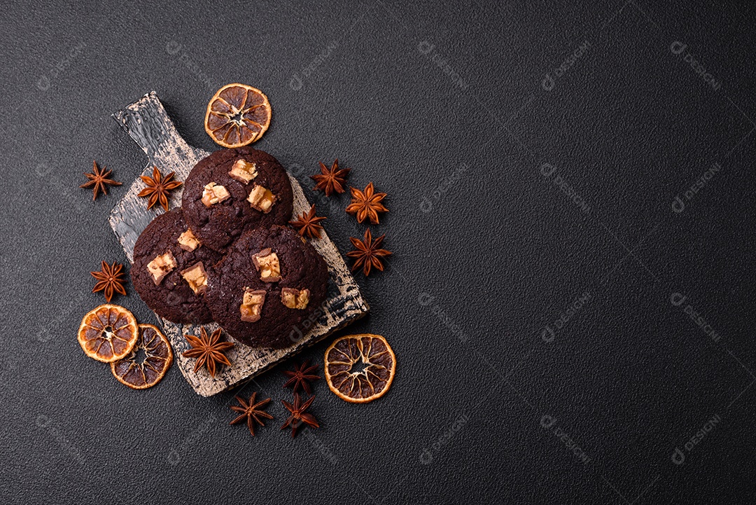 A imagem mostra biscoitos de chocolate, possivelmente cookies, decorados com pedaços de chocolate
