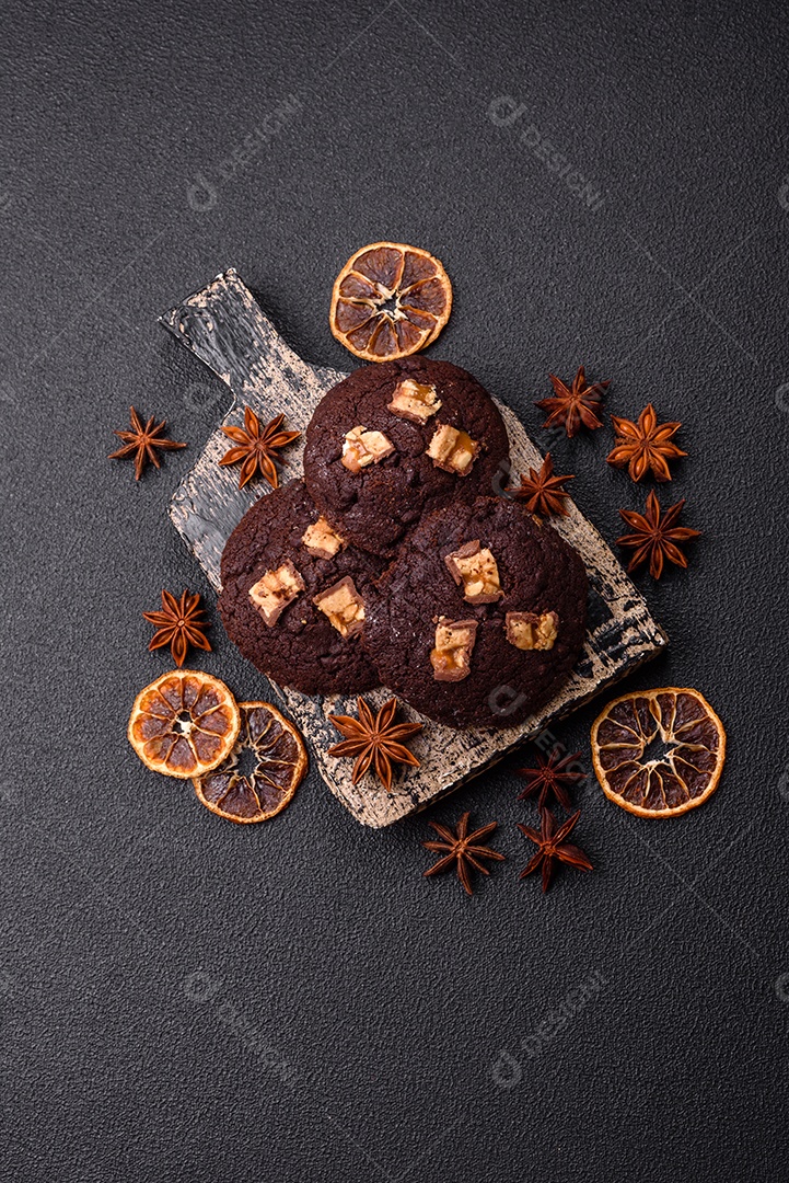 A imagem mostra biscoitos de chocolate, possivelmente cookies, decorados com pedaços de chocolate