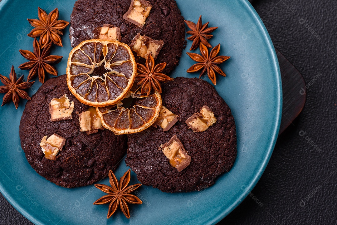 A imagem mostra biscoitos de chocolate, possivelmente cookies, decorados com pedaços de chocolate