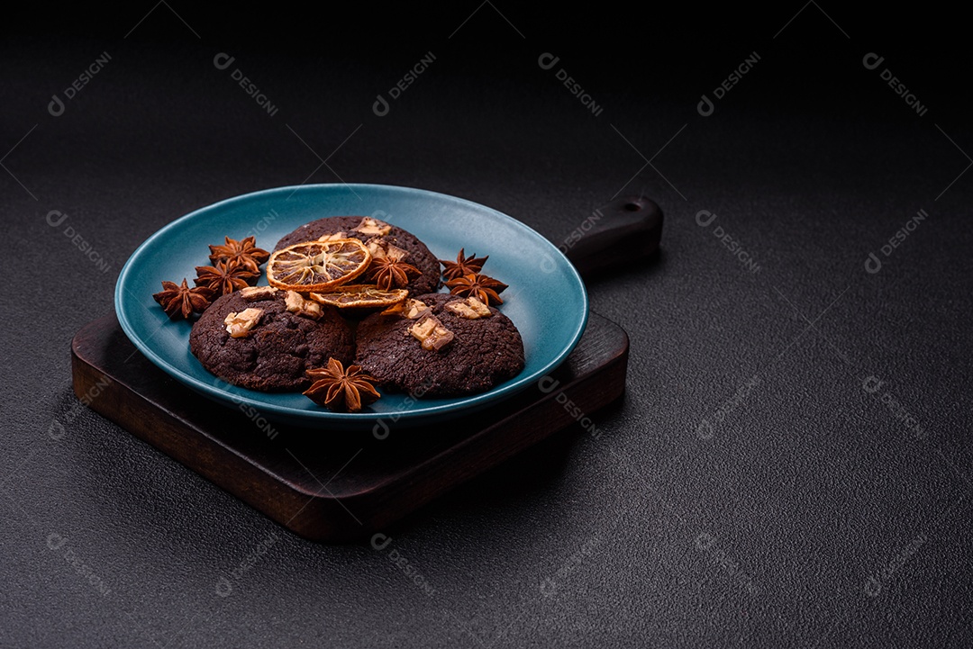 A imagem mostra biscoitos de chocolate, possivelmente cookies, decorados com pedaços de chocolate