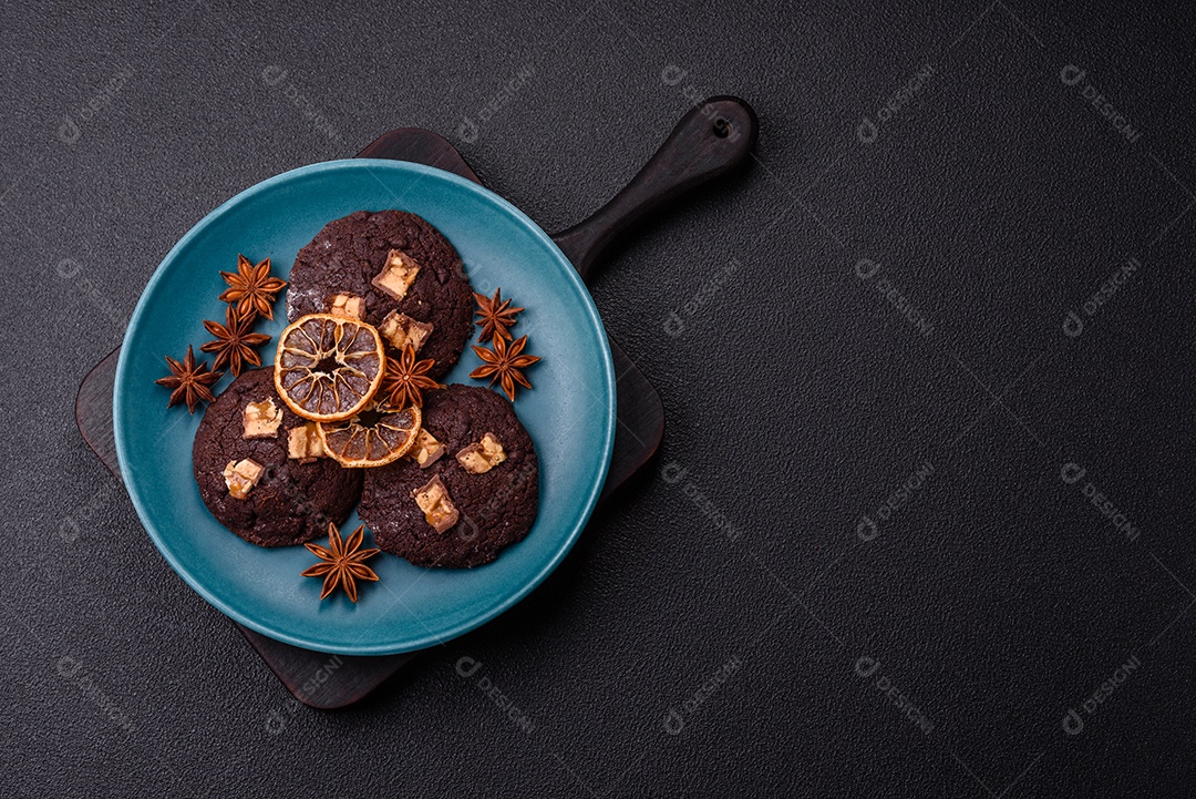 A imagem mostra biscoitos de chocolate, possivelmente cookies, decorados com pedaços de chocolate