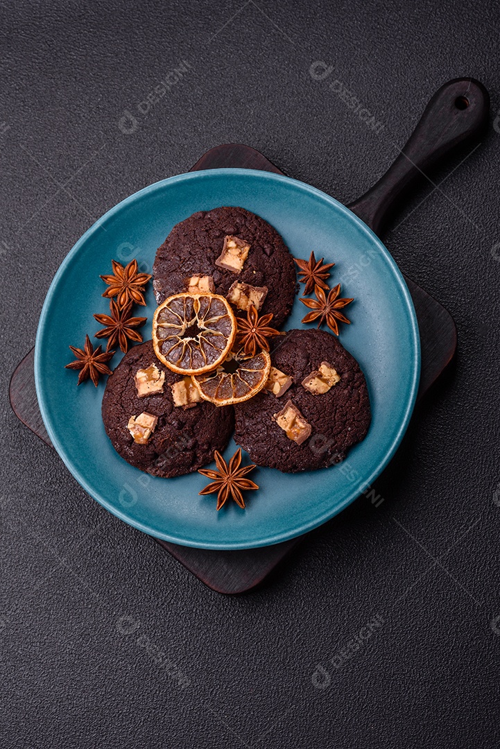A imagem mostra biscoitos de chocolate, possivelmente cookies, decorados com pedaços de chocolate
