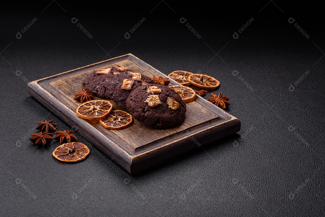 A imagem mostra biscoitos de chocolate, possivelmente cookies, decorados com pedaços de chocolate