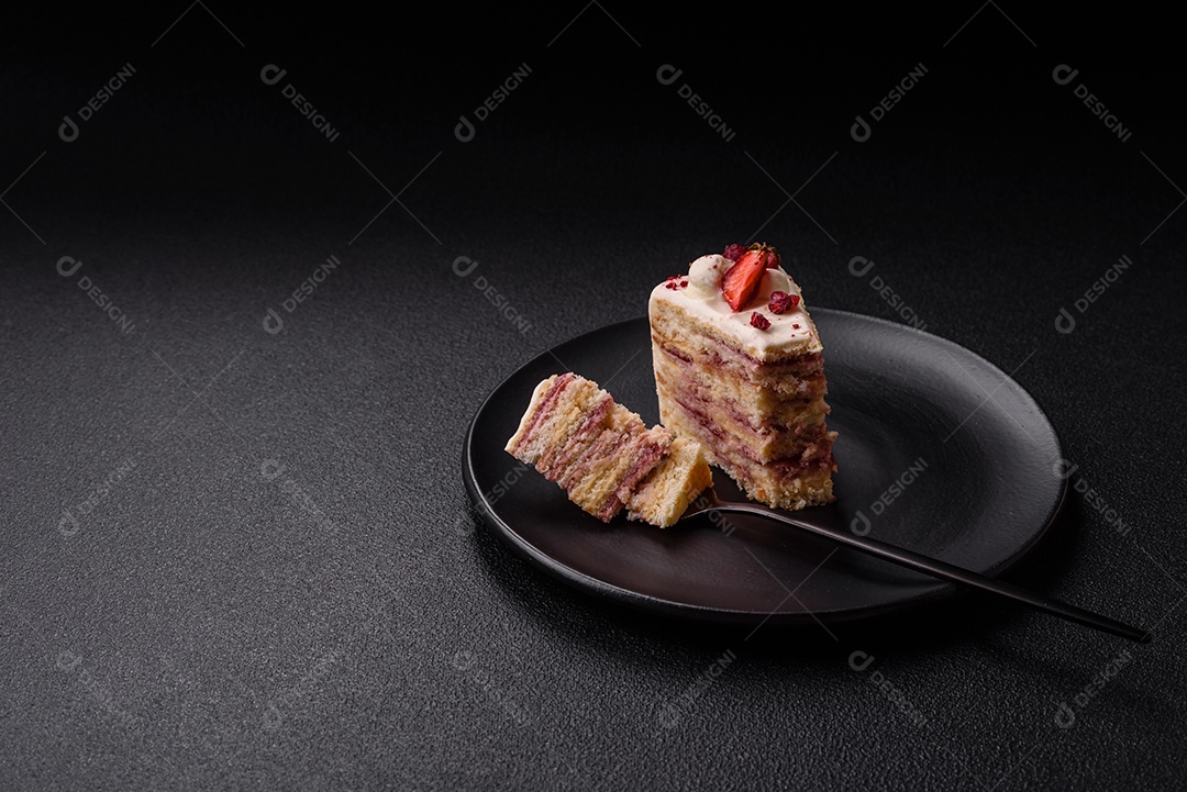 A imagem mostra uma fatia de bolo em um prato preto, com um pedaço menor ao lado e um garfo