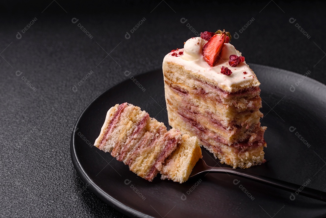 A imagem mostra uma fatia de bolo em um prato preto, com um pedaço menor ao lado e um garfo