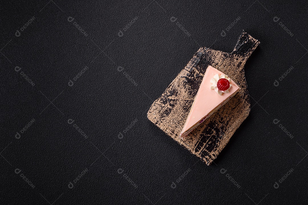 A imagem mostra uma fatia de bolo ou torta com cobertura rosa claro e um topo decorado com uma framboesa fresca