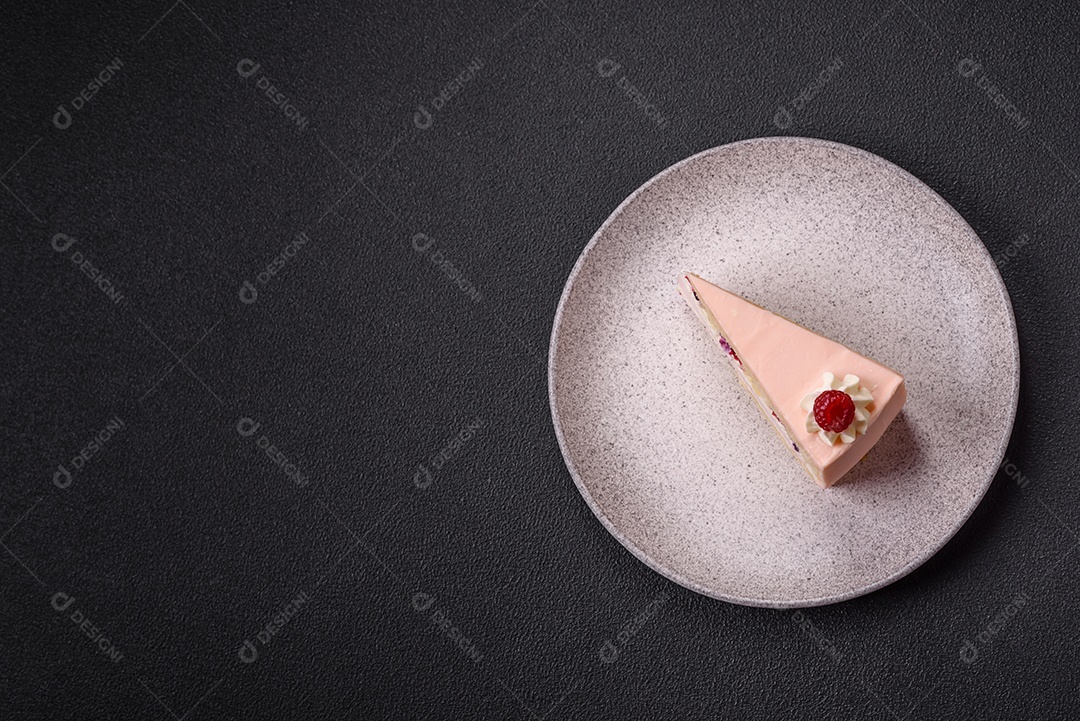 A imagem mostra uma fatia de bolo ou torta com cobertura rosa claro e um topo decorado com uma framboesa fresca