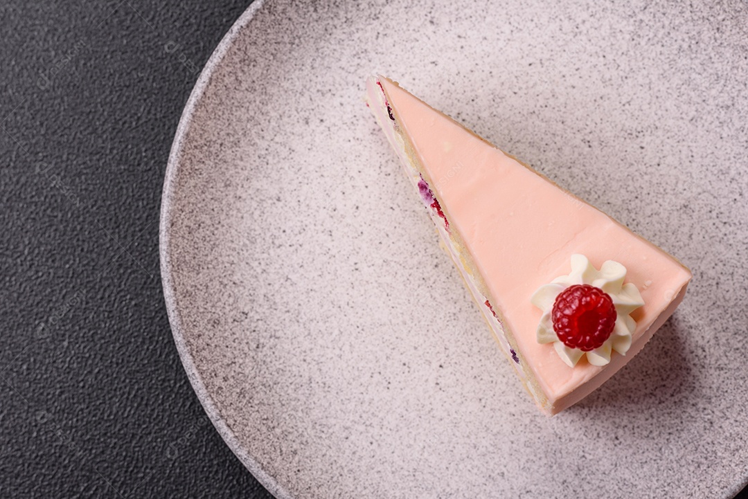 A imagem mostra uma fatia de bolo ou torta com cobertura rosa claro e um topo decorado com uma framboesa fresca