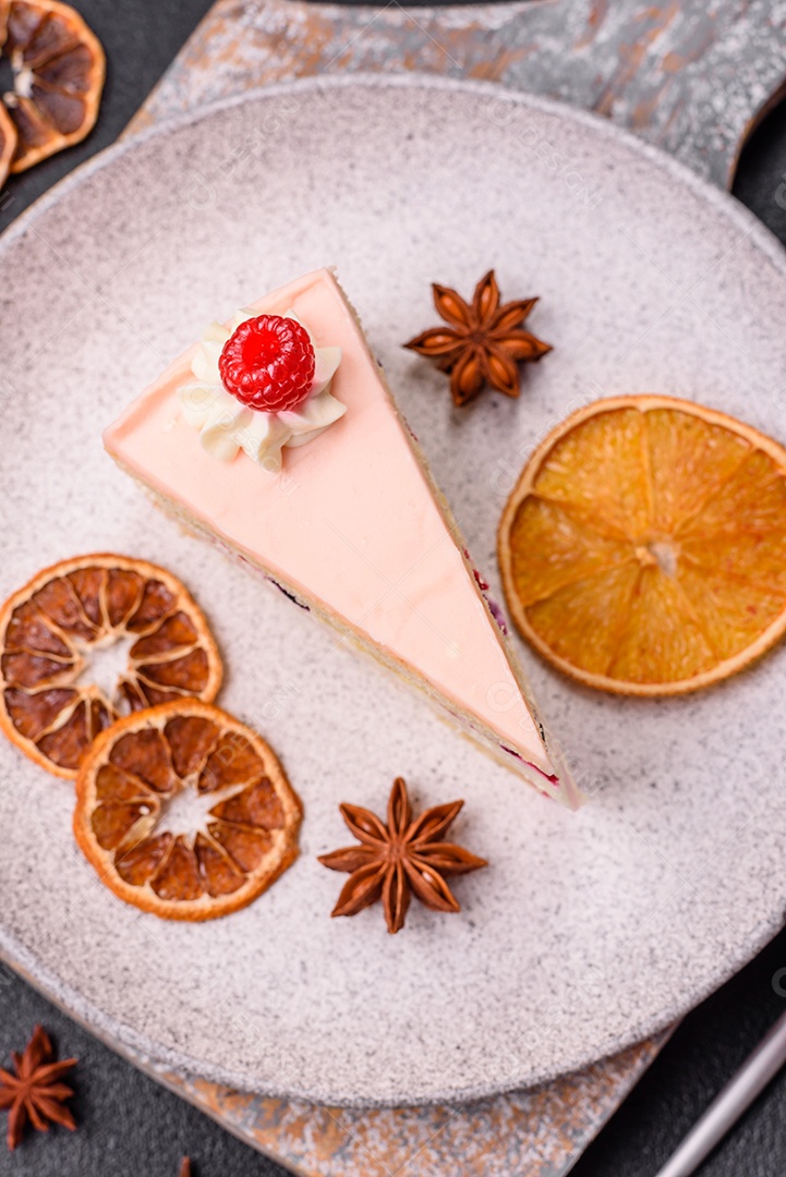 A imagem mostra uma fatia de bolo ou torta com cobertura rosa claro e um topo decorado com uma framboesa fresca