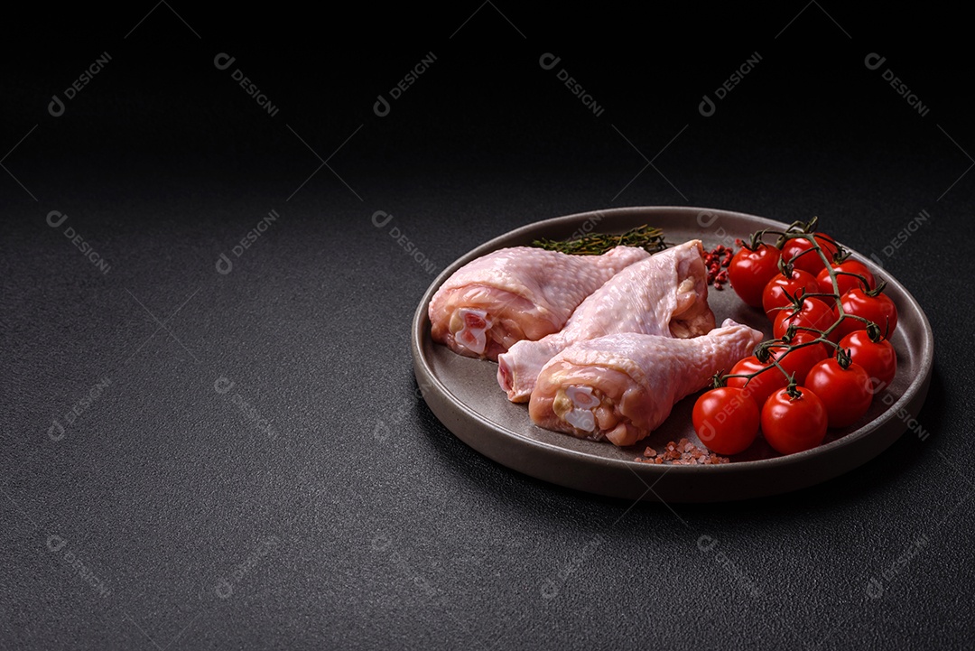 A imagem mostra coxas de frango cruas em um prato, junto com tomates-cereja.