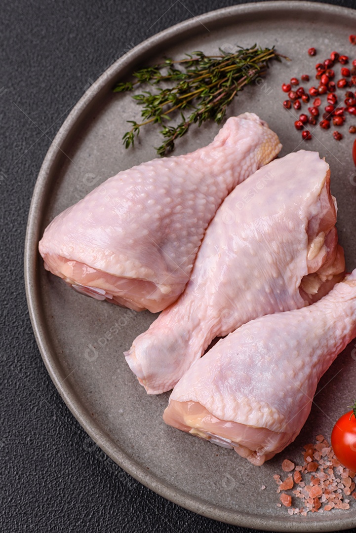 A imagem mostra sobrecoxas de frango cruas, com pele e osso, prontas para serem preparadas