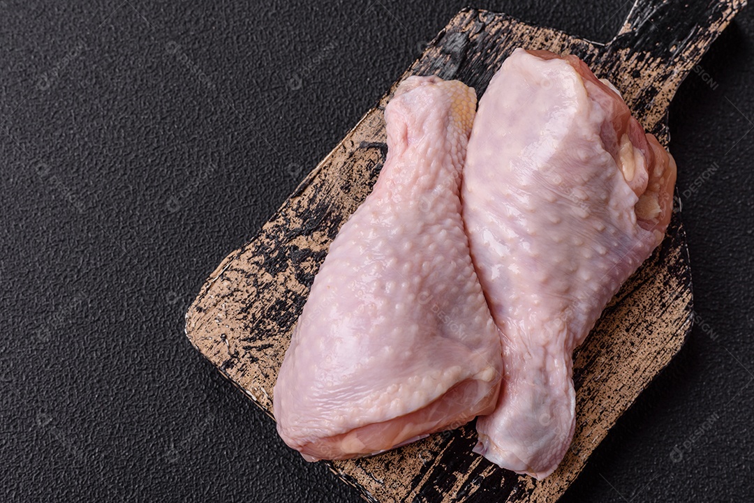 A imagem mostra sobrecoxas de frango cruas, com pele e osso, prontas para serem preparadas