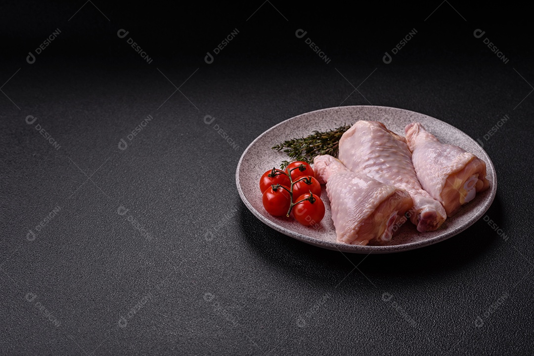 A imagem mostra coxas de frango cruas em um prato, acompanhadas de tomates cereja e ervas frescas.